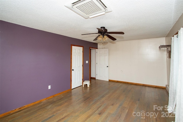 unfurnished room with a textured ceiling, ceiling fan, a baseboard radiator, and dark hardwood / wood-style floors