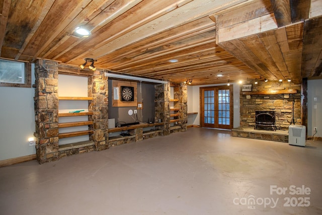 basement with a stone fireplace, wooden ceiling, and french doors