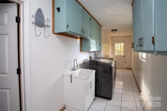 washroom with cabinets, sink, light tile patterned floors, separate washer and dryer, and a baseboard radiator