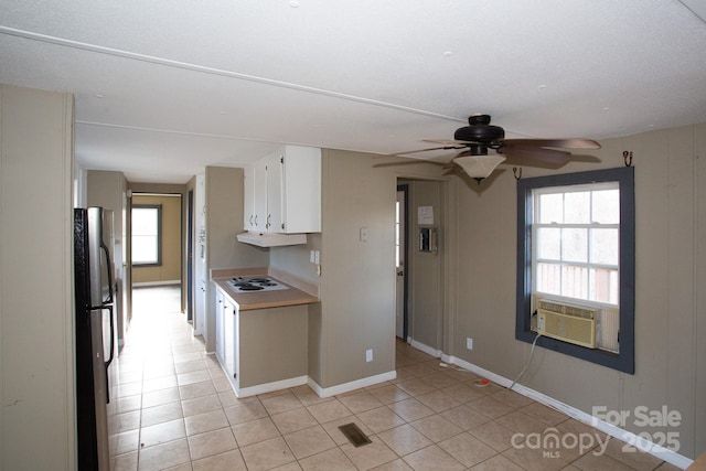 kitchen with white gas cooktop, light tile patterned flooring, stainless steel fridge, cooling unit, and white cabinets