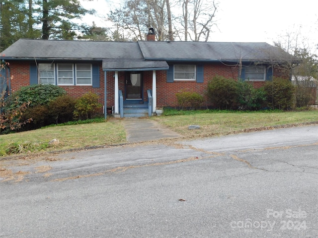 single story home featuring a front lawn