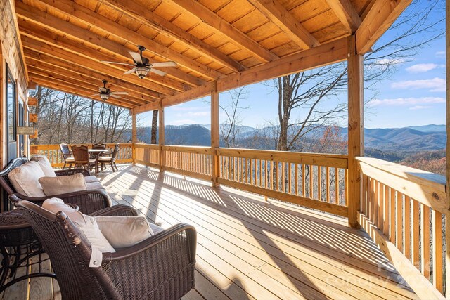 wooden terrace featuring a mountain view and ceiling fan