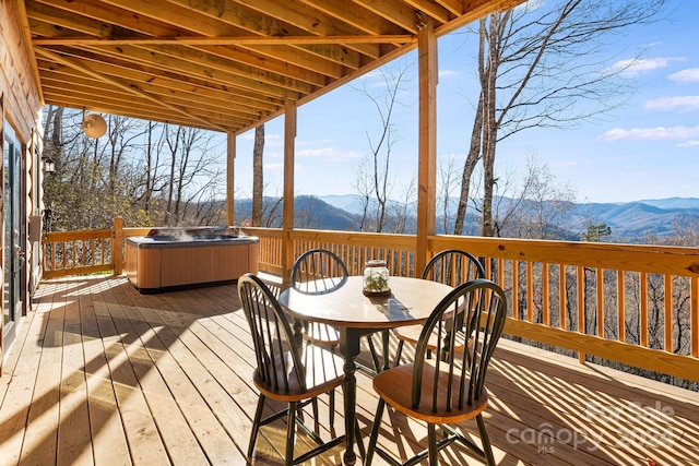 deck with a mountain view and a hot tub