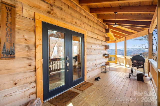 deck with a mountain view, french doors, and a porch