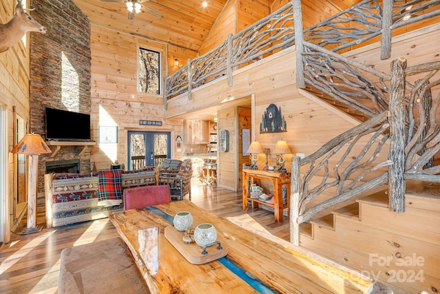 dining room with wood-type flooring, high vaulted ceiling, wood ceiling, and wood walls