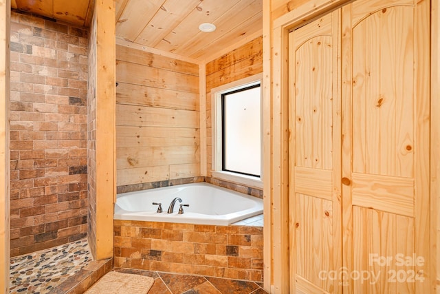 bathroom featuring a relaxing tiled tub, tile patterned floors, and wood ceiling