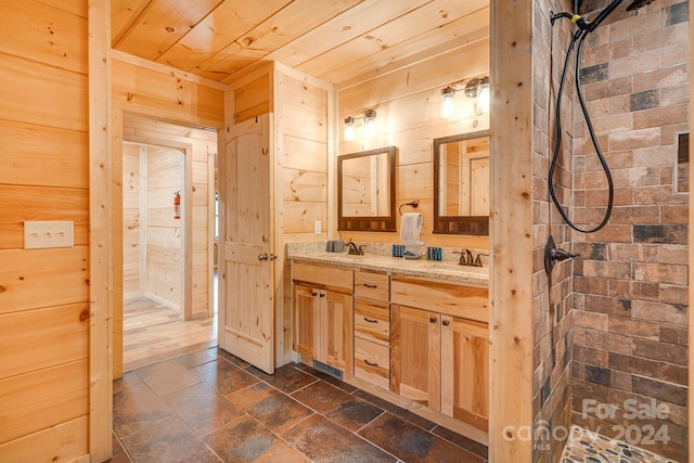 bathroom featuring tiled shower, vanity, wood ceiling, and wood walls