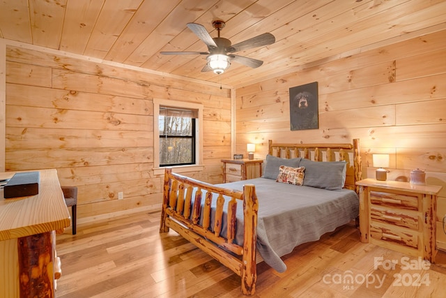 bedroom featuring ceiling fan, light hardwood / wood-style flooring, and wood walls