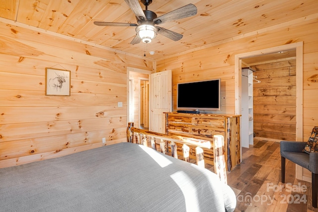 bedroom with hardwood / wood-style floors, ceiling fan, wood ceiling, and wooden walls