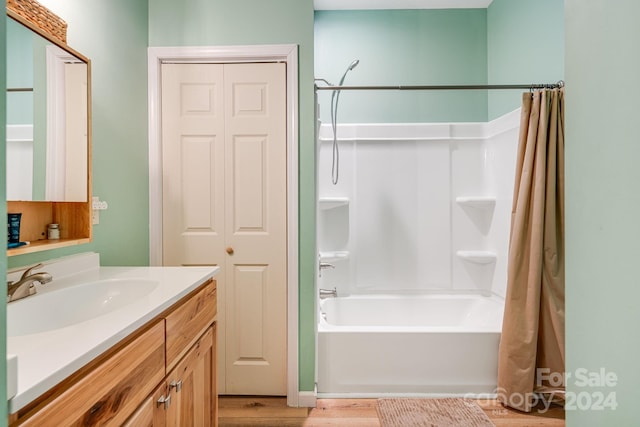 bathroom with wood-type flooring, vanity, and shower / bath combo with shower curtain