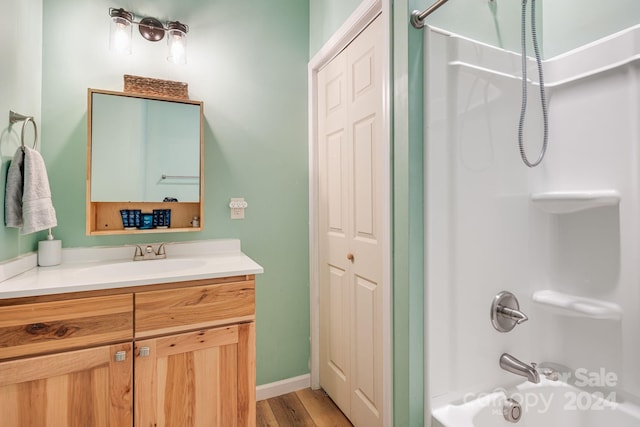 bathroom with shower / bathing tub combination, vanity, and hardwood / wood-style floors