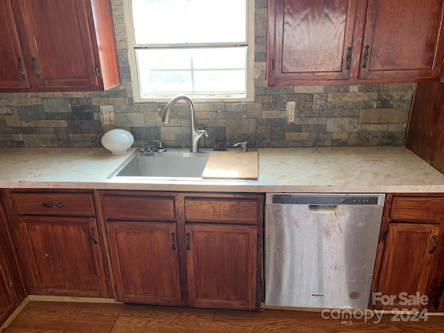 kitchen featuring dishwasher, sink, and tasteful backsplash