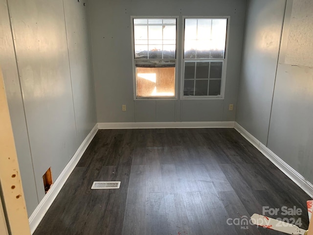 unfurnished room with dark wood-type flooring