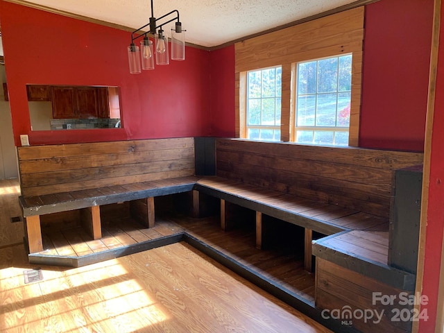 unfurnished dining area featuring wood-type flooring and a textured ceiling