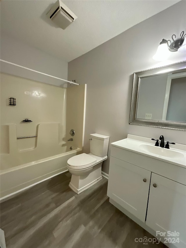 full bathroom featuring vanity, wood-type flooring, shower / bathtub combination, and toilet