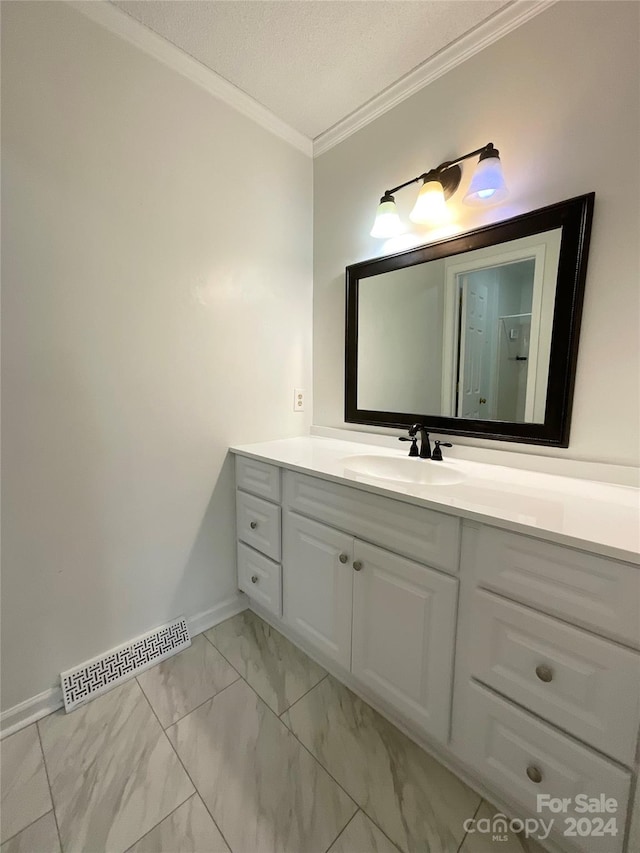 bathroom featuring a textured ceiling, vanity, and ornamental molding