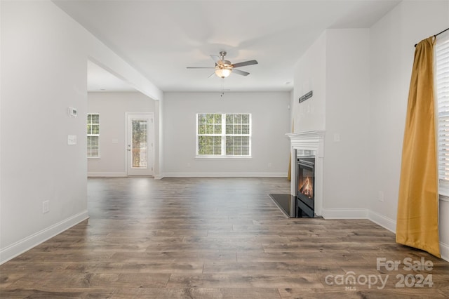 unfurnished living room with dark hardwood / wood-style floors and ceiling fan