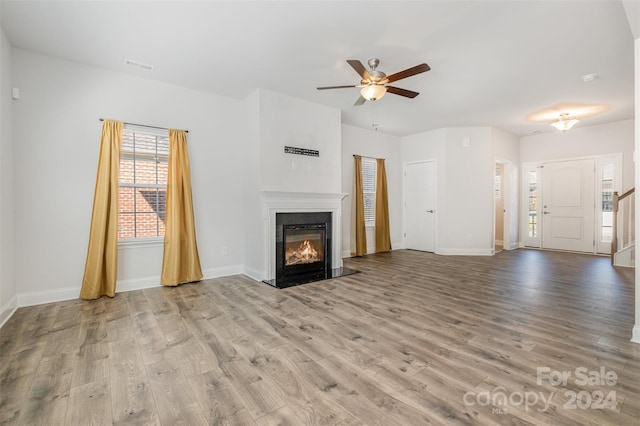 unfurnished living room with light wood-type flooring and ceiling fan