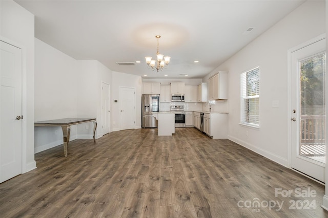 kitchen featuring pendant lighting, dark wood-type flooring, white cabinets, appliances with stainless steel finishes, and a kitchen island