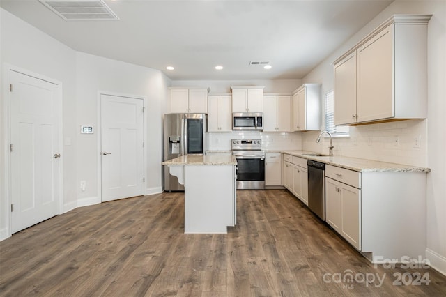 kitchen with dark wood-type flooring, sink, a kitchen island, and stainless steel appliances