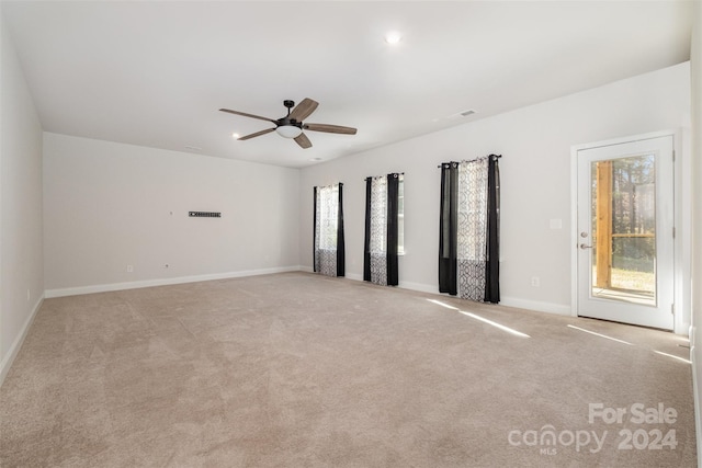 carpeted spare room with ceiling fan