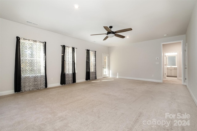 empty room with ceiling fan and light colored carpet