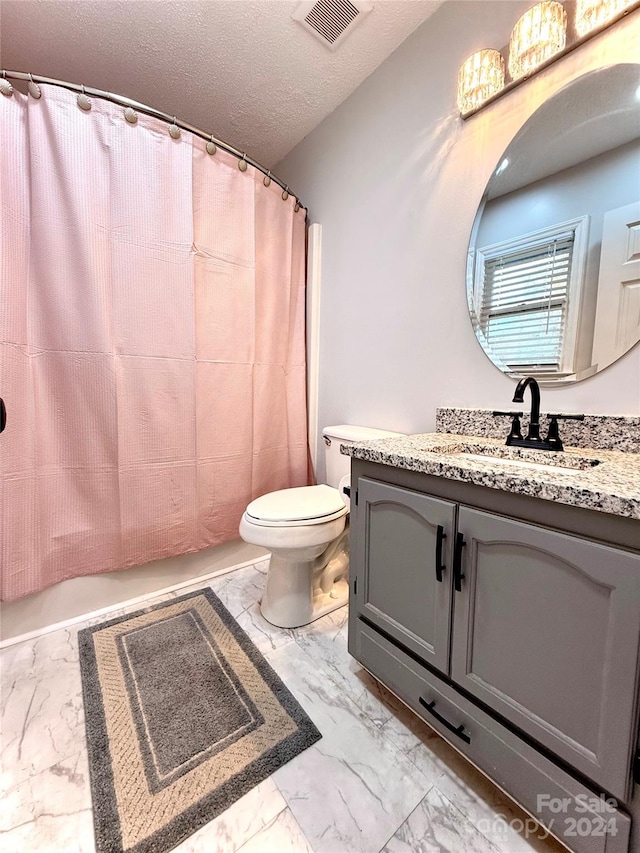 bathroom featuring a shower with curtain, vanity, a textured ceiling, and toilet