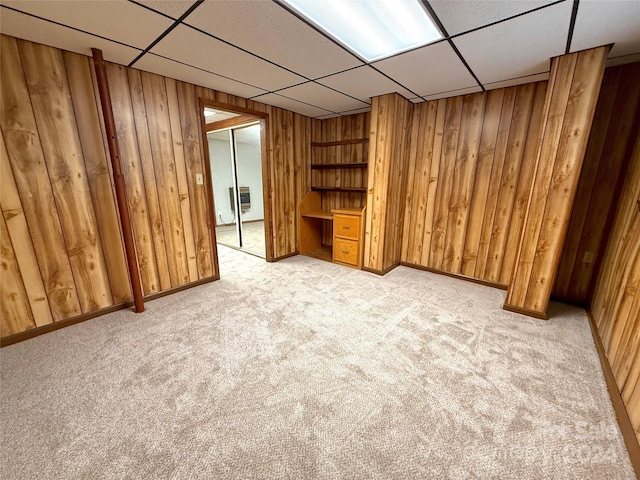 interior space featuring light carpet, wooden walls, and heating unit