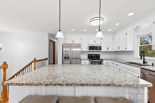 kitchen featuring stainless steel appliances, decorative backsplash, a sink, and pendant lighting