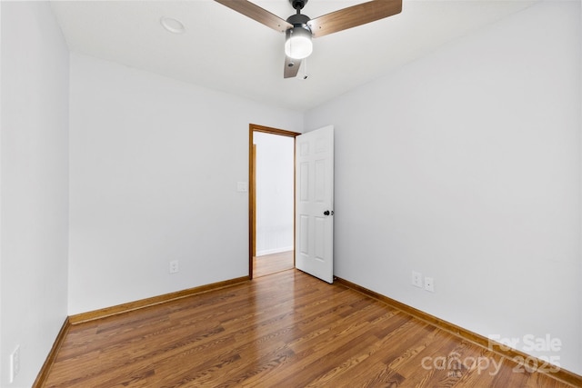 spare room with a ceiling fan, baseboards, and wood finished floors