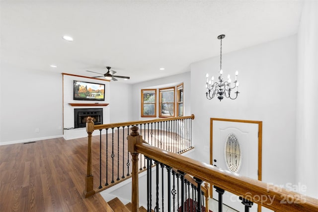 corridor with recessed lighting, wood finished floors, visible vents, an upstairs landing, and baseboards