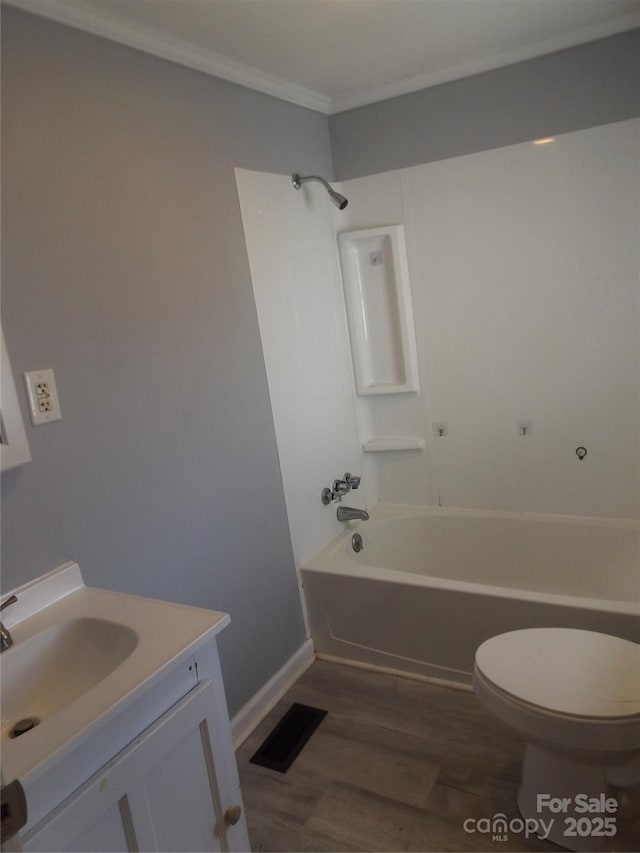 full bathroom featuring wood-type flooring, toilet, vanity, shower / bathtub combination, and ornamental molding