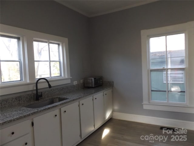 kitchen featuring white cabinets, dark hardwood / wood-style floors, light stone counters, and sink