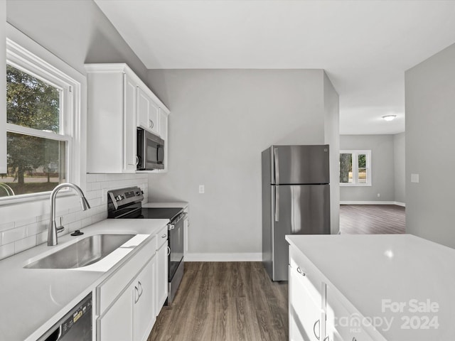 kitchen featuring decorative backsplash, appliances with stainless steel finishes, dark hardwood / wood-style flooring, sink, and white cabinets