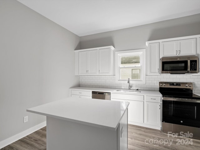 kitchen featuring a center island, sink, light hardwood / wood-style floors, white cabinetry, and stainless steel appliances