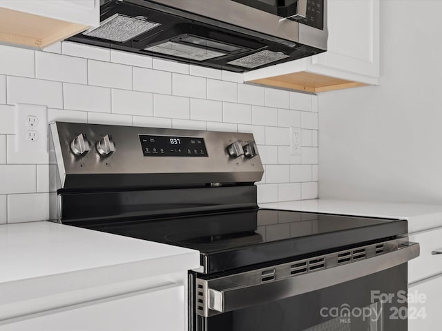 kitchen featuring backsplash, white cabinetry, and stainless steel appliances