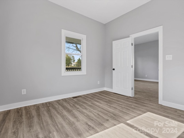 unfurnished room with hardwood / wood-style floors