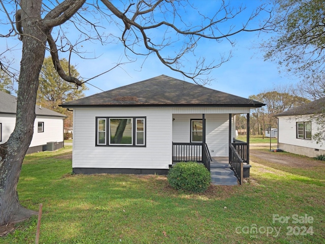 bungalow-style house with central air condition unit, covered porch, and a front yard