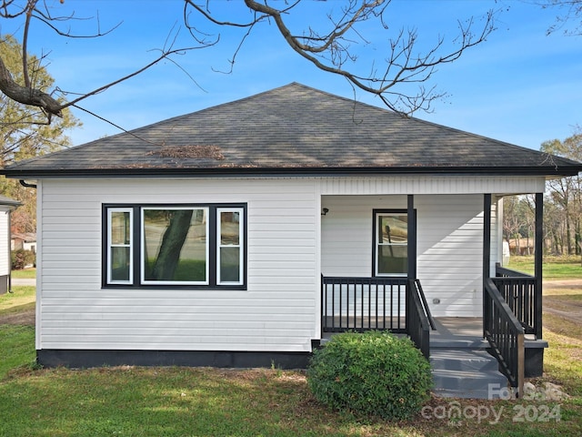 back of house featuring a yard and a porch