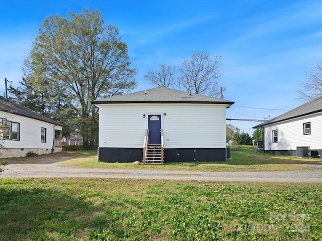 rear view of house with a lawn and cooling unit