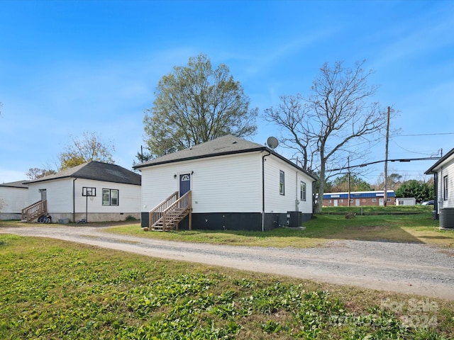 exterior space featuring central AC unit and a lawn