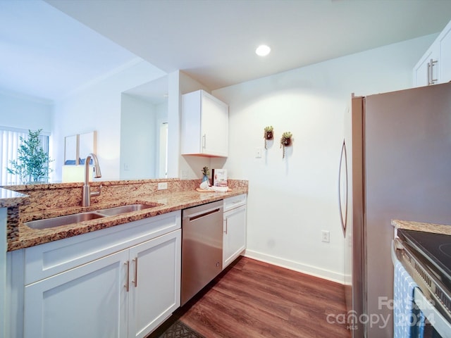 kitchen with light stone counters, stainless steel appliances, sink, white cabinets, and dark hardwood / wood-style floors