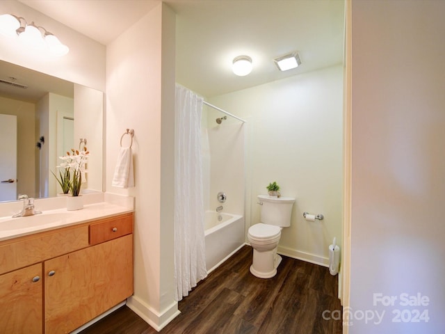 full bathroom featuring hardwood / wood-style floors, vanity, shower / tub combo, and toilet