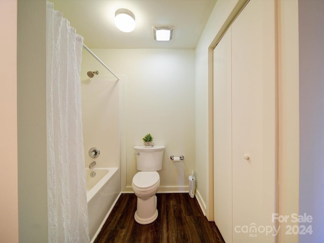 bathroom with hardwood / wood-style floors, shower / bath combination with curtain, and toilet