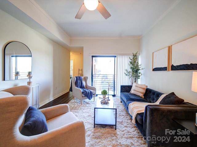 living room featuring wood-type flooring, ceiling fan, and ornamental molding