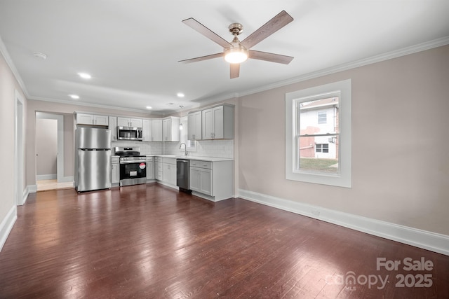 kitchen with appliances with stainless steel finishes, decorative backsplash, and ornamental molding