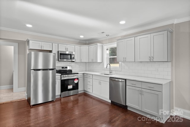 kitchen featuring stainless steel appliances, tasteful backsplash, dark hardwood / wood-style flooring, ornamental molding, and sink