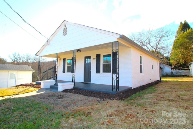 bungalow-style home with covered porch and a front yard