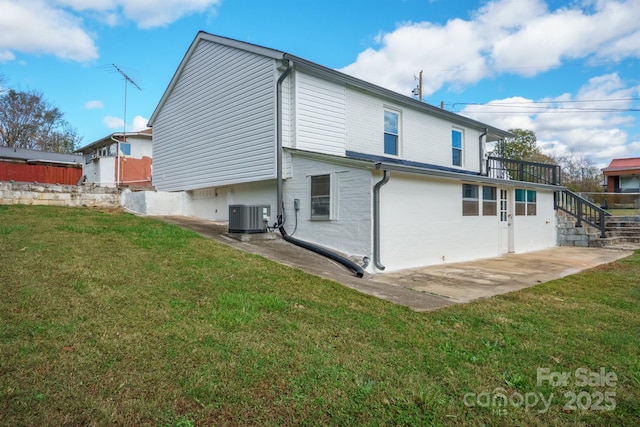 rear view of property featuring a patio area, a lawn, and central AC