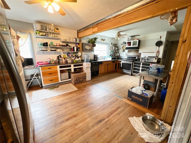 kitchen with light wood-type flooring, a textured ceiling, ceiling fan, stainless steel range oven, and dishwasher